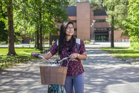 Young woman with a bike outside at campus area.