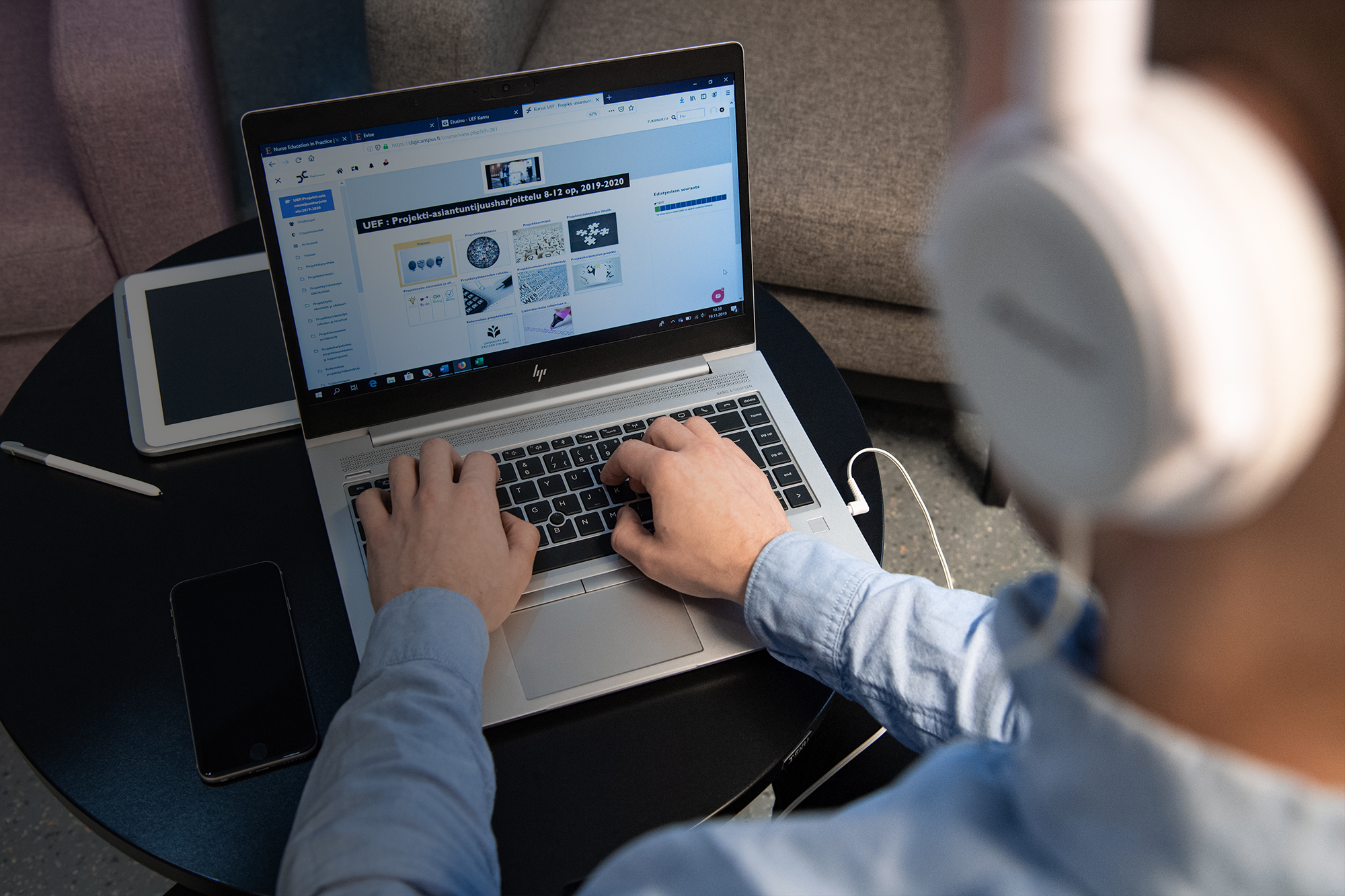 Mies suorittaa projektiasiantuntijuuden opintoja tietokoneella.