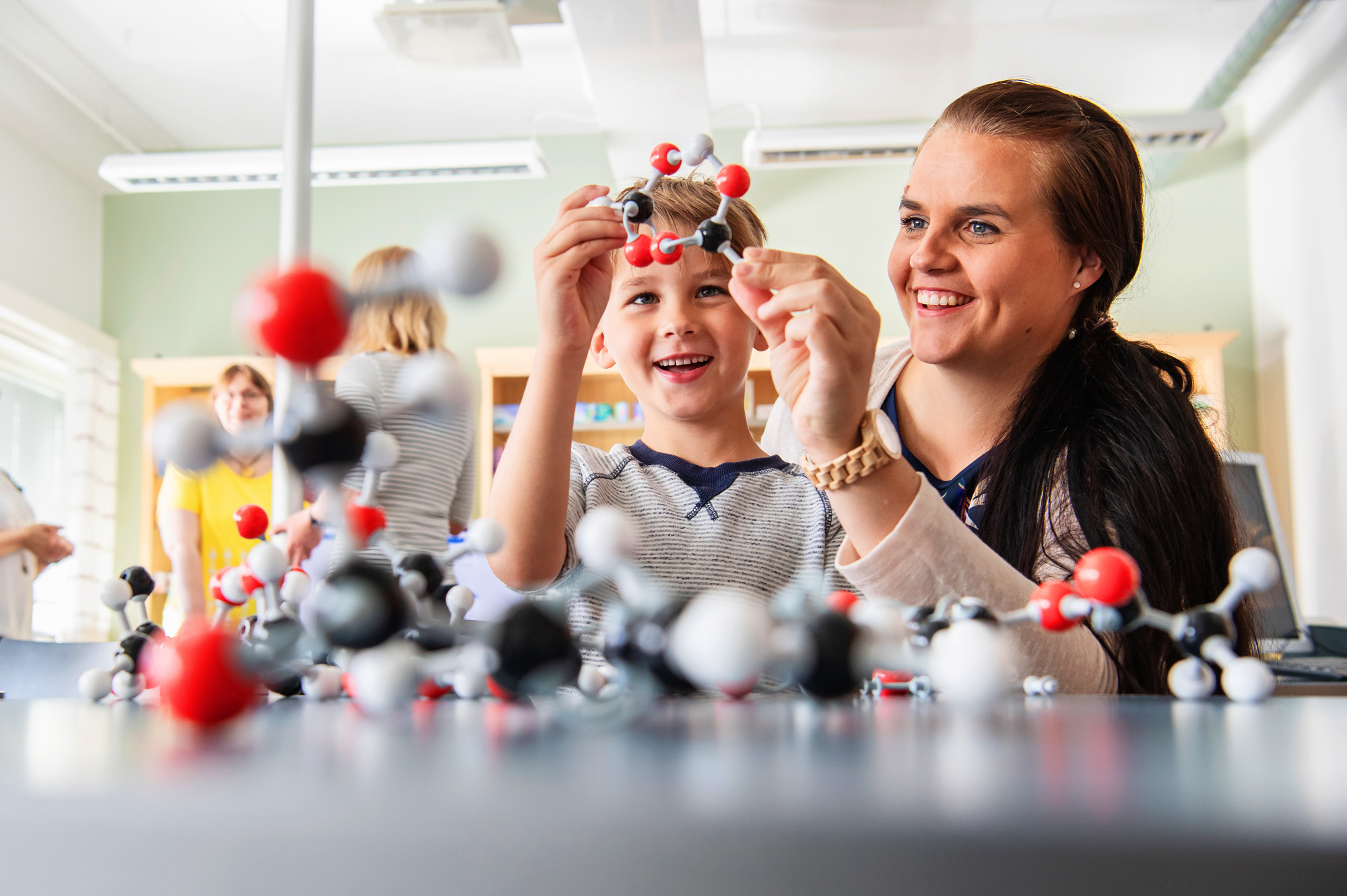 Äiti ja lapsi rakentamassa molekyylimalleja.