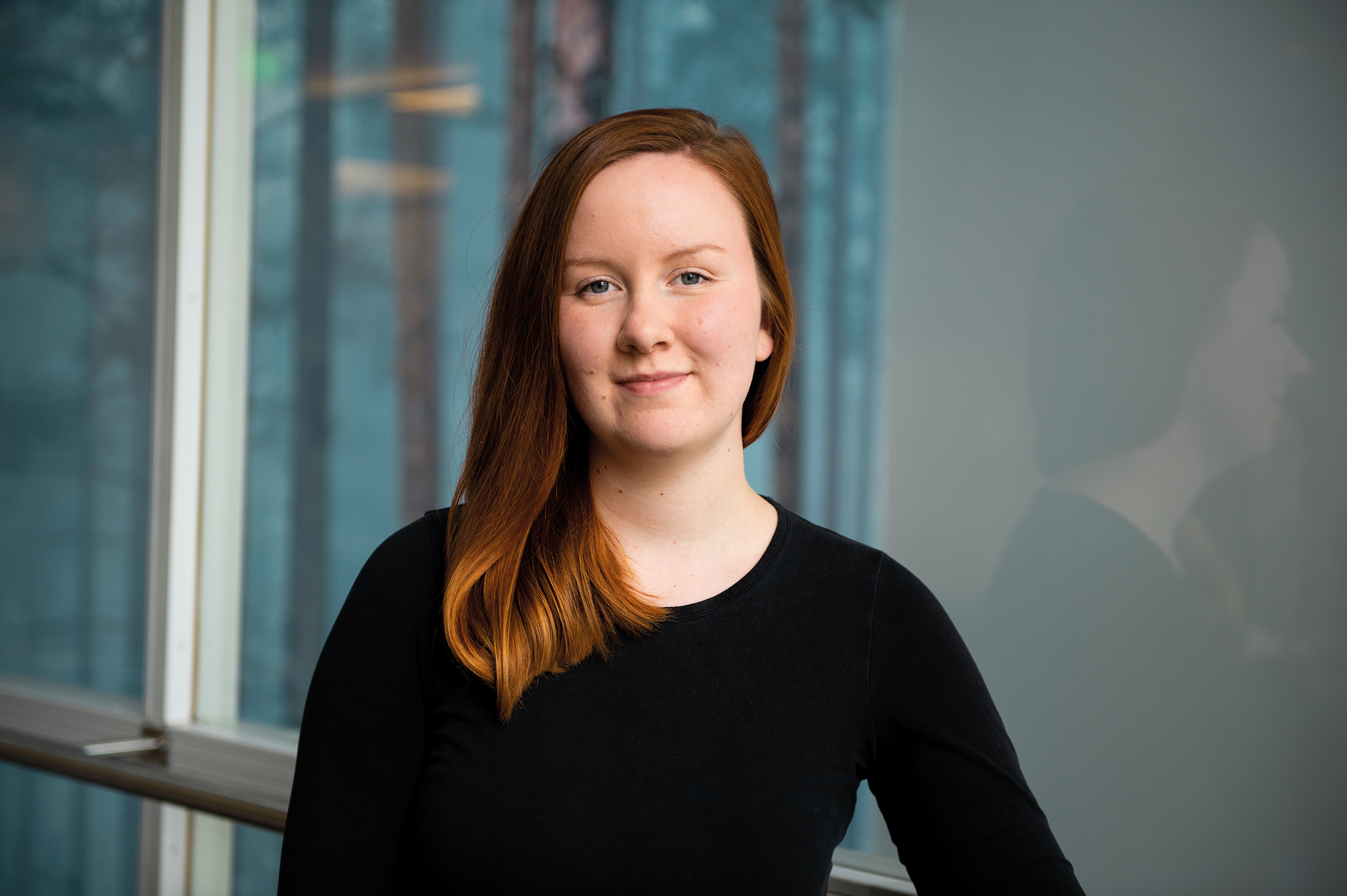 Opiskelija seisoo ikkunan edessä