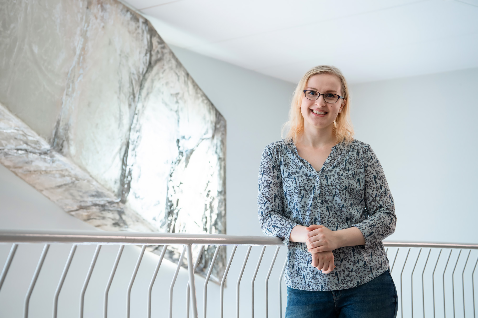 Student standing in front of a handrail.