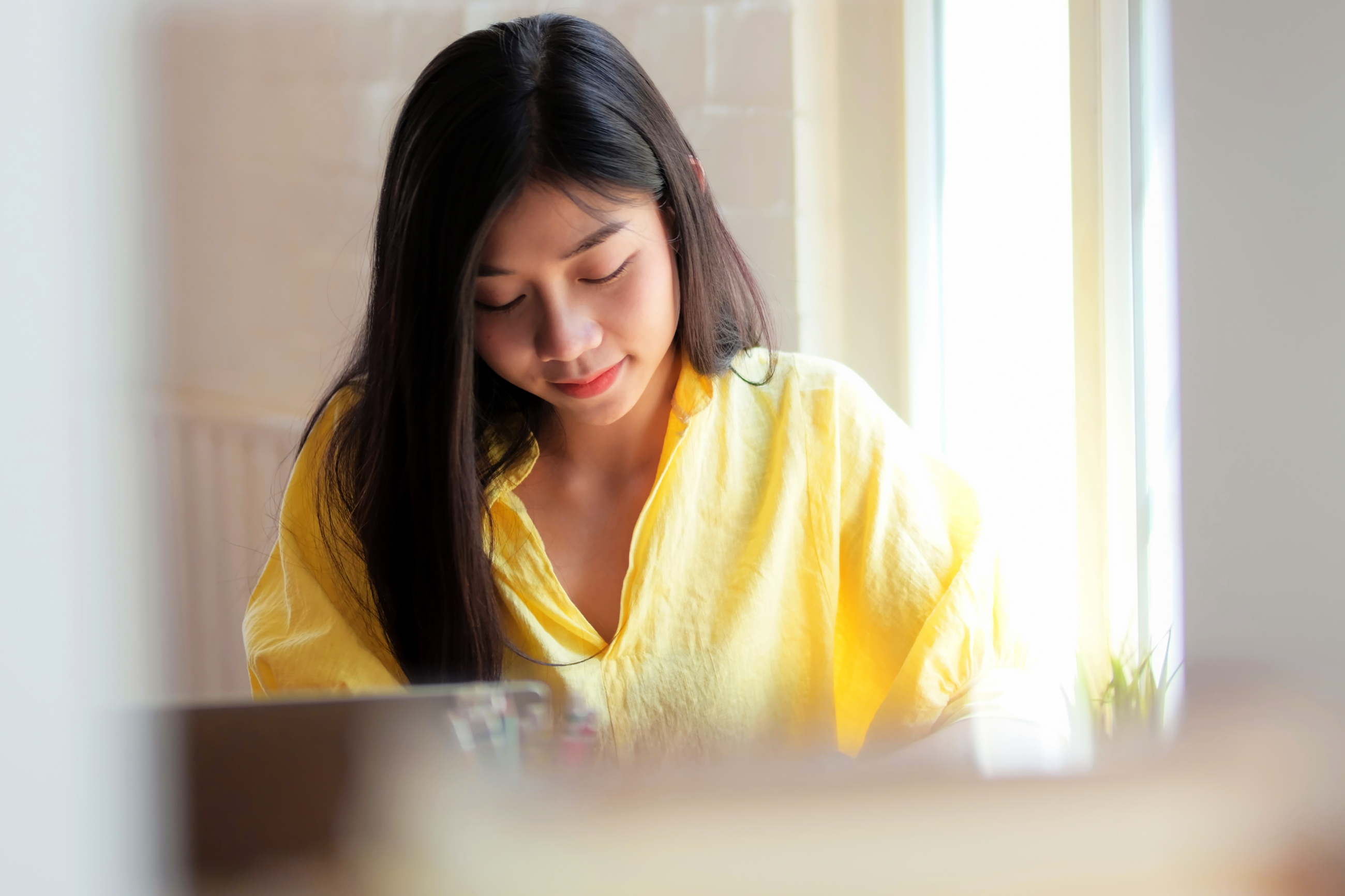 Nuori nainen katse käännettynä alas jonkin asian pariin jonka kanssa työskentelee.