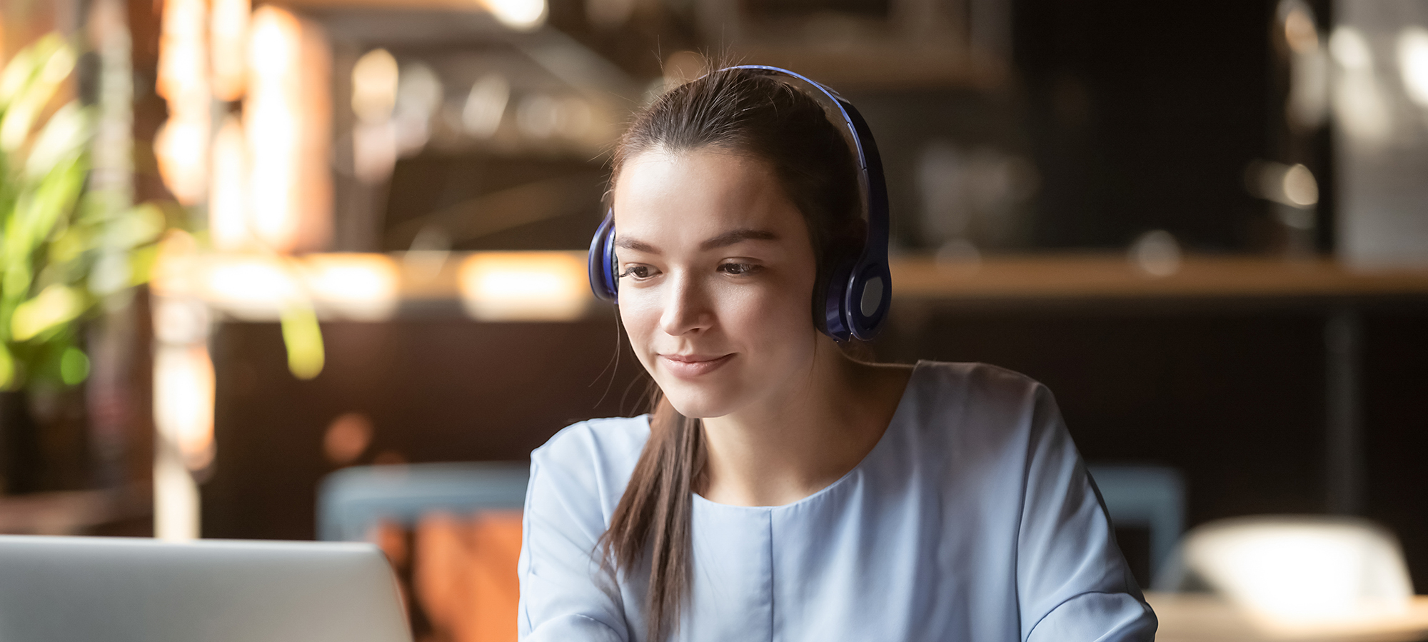 nainen opiskelemassa kuulokkeet korvilla