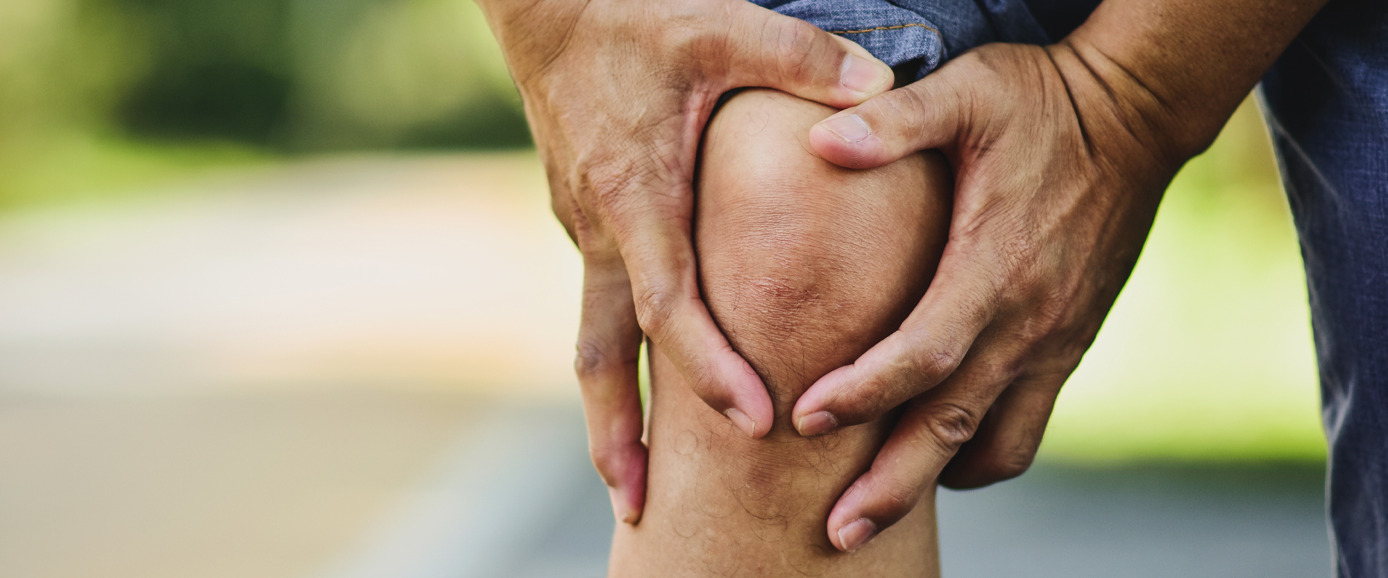 Mies pitelee kipeää polvea.