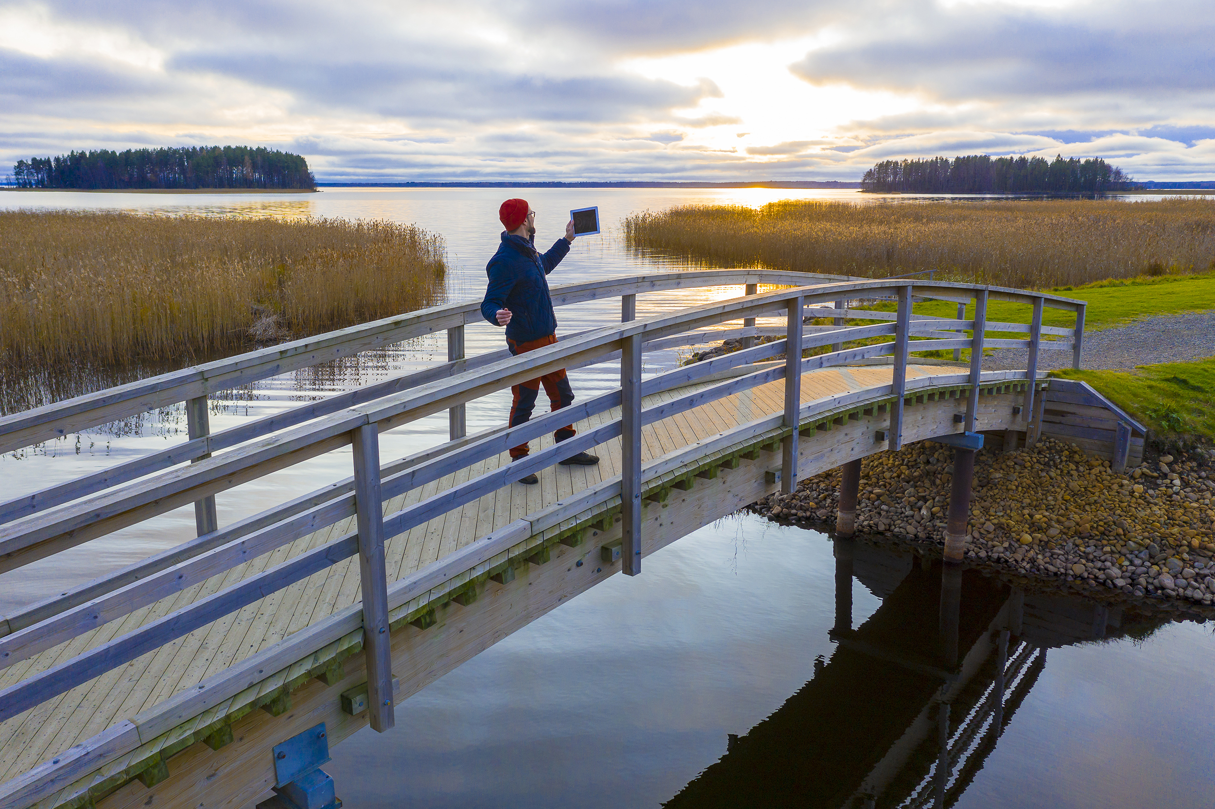 Mies seisoo sillalla pädi kädessään