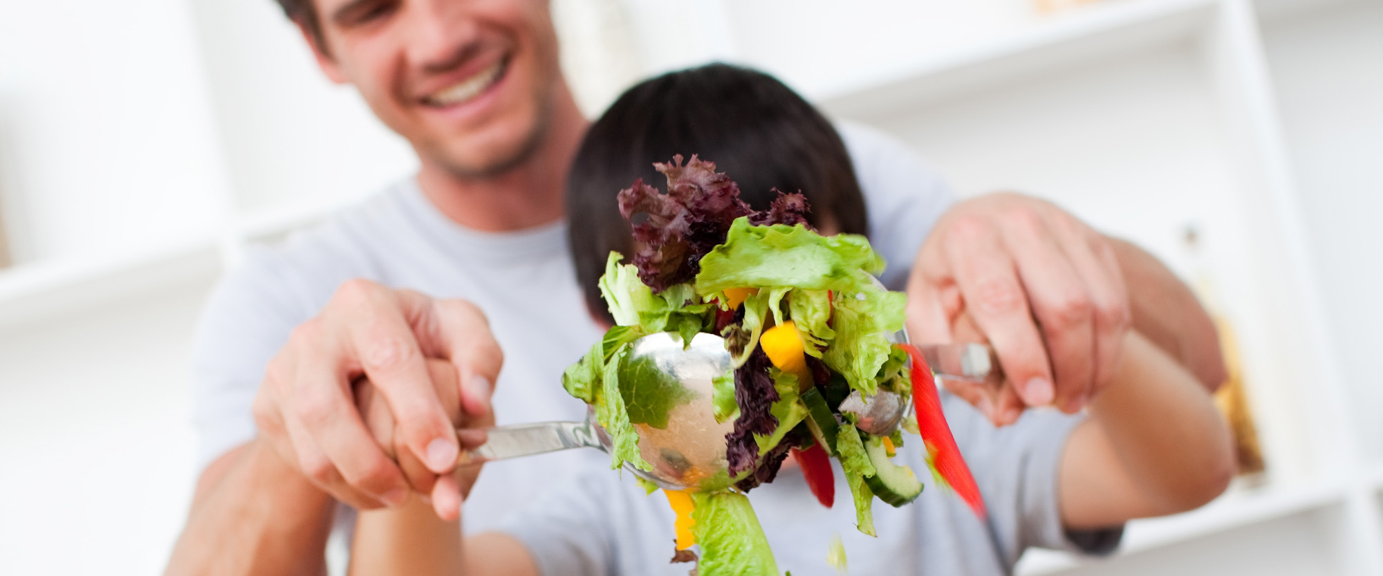 Mies ja poika tekevät salaattia.