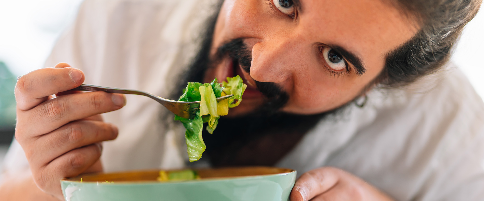 Mies syö salaattia.