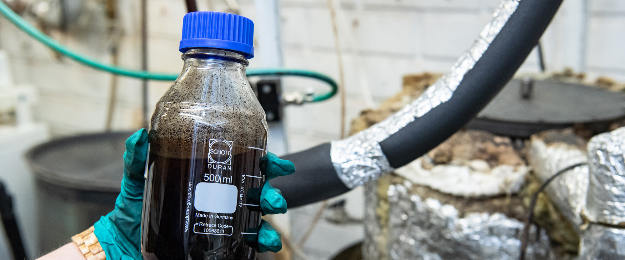 Nestepullo kädessä.