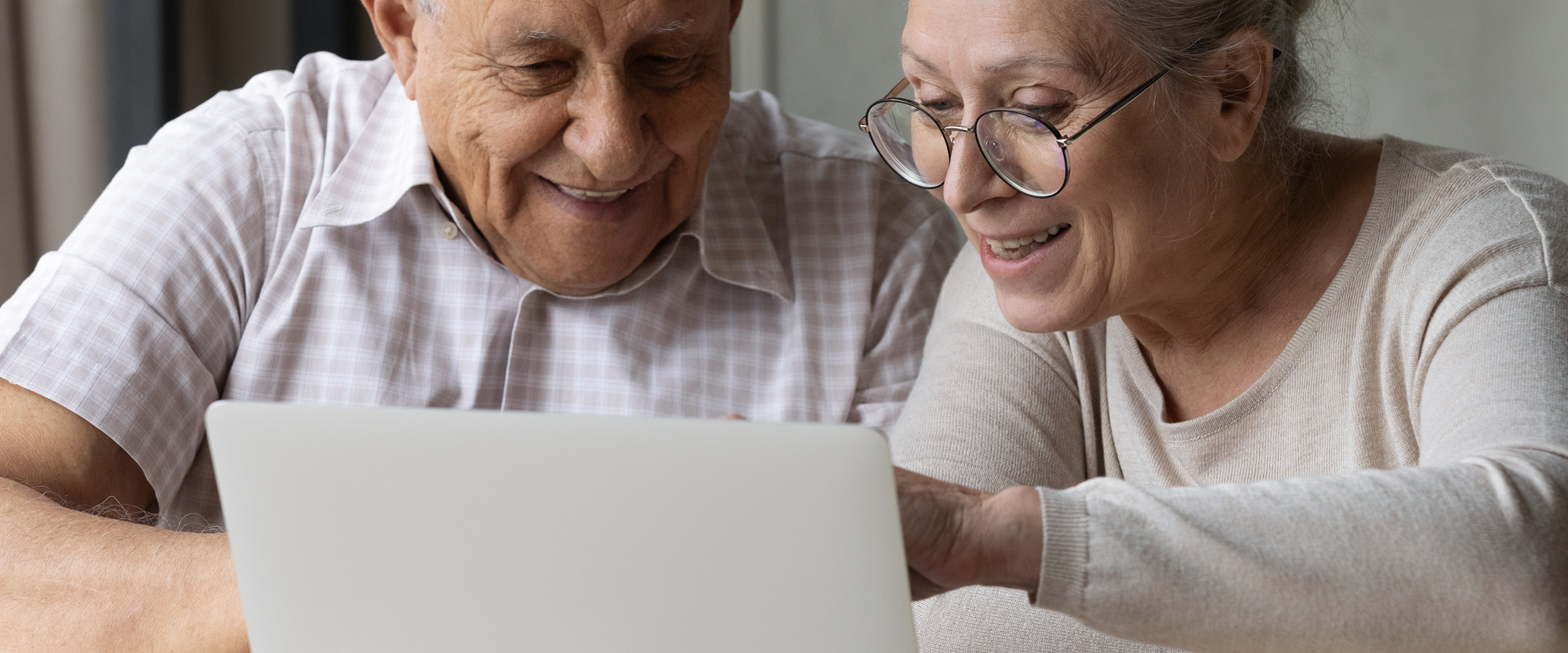 Vanha mies ja nainen tietokoneen ääressä.