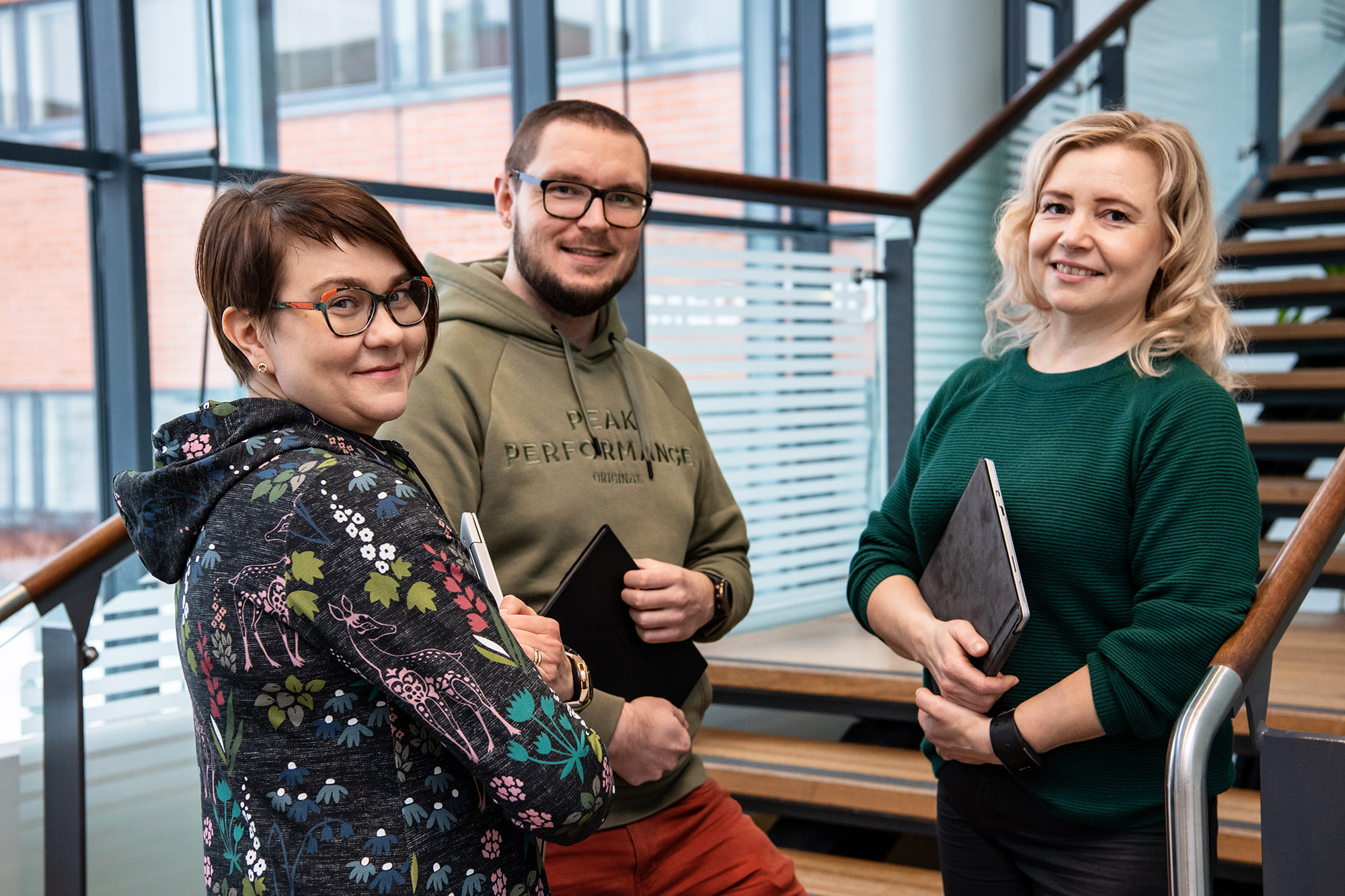 Kolme henkilöä seisoo ikkunan edessä.