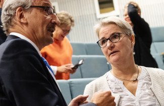 Mies ja nainen keskustelevat luentosalissa.