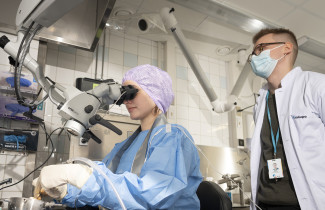 Väitöskirjatutkija Jesse Tapiala seuraa sormituntumaltaan lähellä todellisuutta olevan 3D-tulostetun ohimoluumallin porausta.