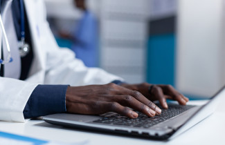 Doctor&#039;s hands on a laptop keyboard.