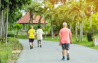 Elderly man walking in a park.