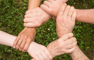 kuusi kättä ranteista kiinni toisissaan, six hands clasped at the wrists
