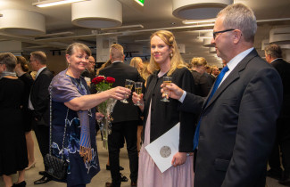 Lääketieteen lisensiaatti Hanna Haverinen nosti maljaa vanhempiensa Minna-Liisa ja Heimo Haverisen kanssa valajuhlassa 7.10.2023.