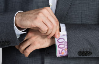 Käsi vetää seteliä hihansuusta.