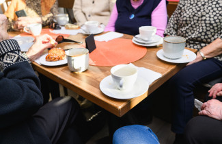 Ryhmä eläkeläisiä kokoontuneena kahvilaan.