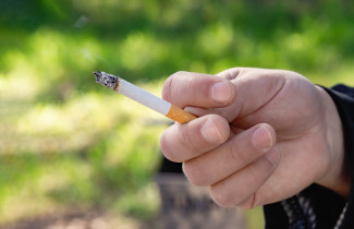 Hand holdig a cigarette.