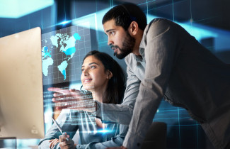 Kaksi henkilöä tietokoneella.