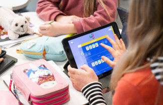 Oppilas tekee tehtäviä älylaitteella. 