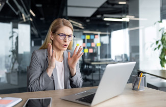 Työntekijä etäpalaverissa kannettavan tietokoneen äärellä.