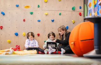 Opettaja tekemässä koululaisten kanssa tehtäviä.