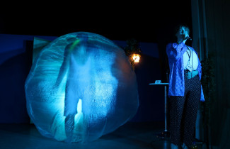 Kaksi henkilöä teatterilavalla.