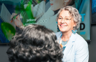 Nainen hymyilee toiselle henkilölle