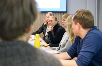 Ihmisiä kokoushuoneessa.