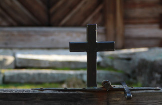 Vanha risti hirsitalon edessä.