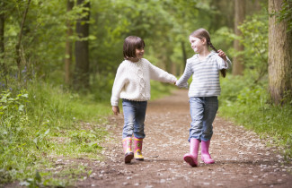 Tyttöjä kävelyllä metsässä.