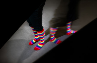 A picture of pride socks that diverge in different directions.