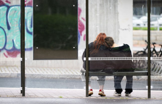 Two people at a bus stop.