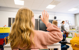 Alakoulun oppilas viittaa tunnilla.