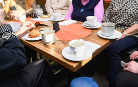 Ryhmä eläkeläisiä kokoontuneena kahvilaan.