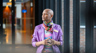 Student standing in a corridor and looking outside