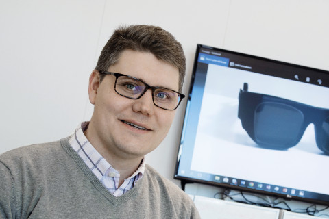 Photo of Petri Stenberg in front of a computer screen showing smart glasses.