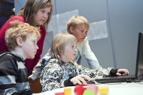 Lapset katsovat kannettavan tietokoneen ruutua