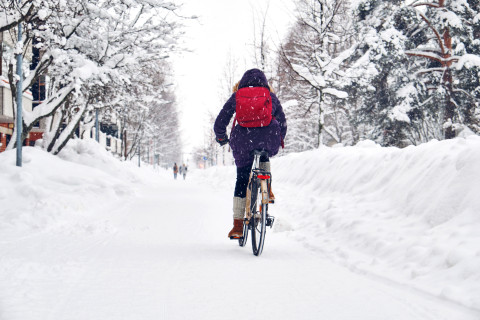Student cycling on the snowy street