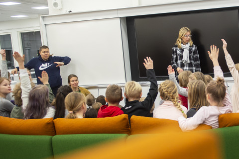 Opettajia ja lapsia luokan sohvalla.