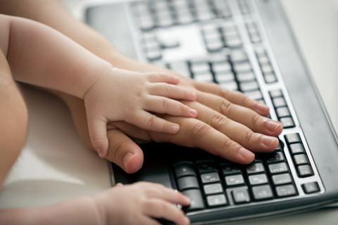 Aikuisen ja lapsen kädet tietokoneen näppäimistöllä