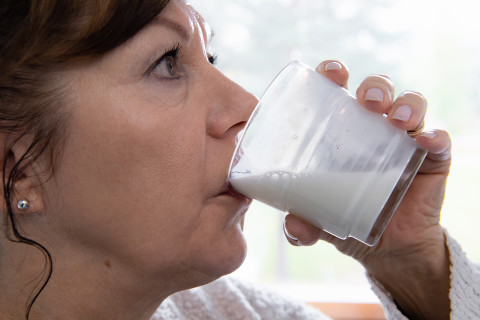 Nainen juo maitotuotetta