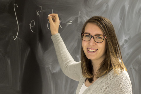 Opiskelija taulun edessä.