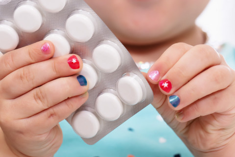 Child holding a blister pack.