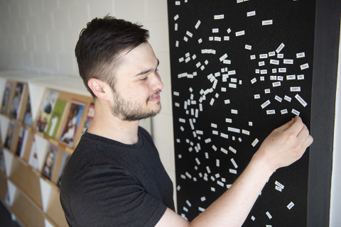 Young man playing with magnetic words.