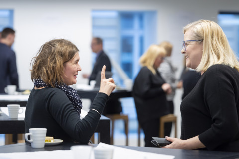 Two women discussing in a cafeteria