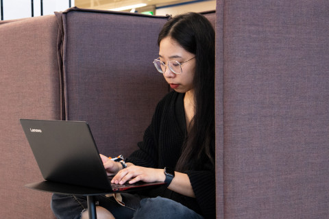 Nuori nainen työskentelee tietokoneella UEFin kirjastossa.
