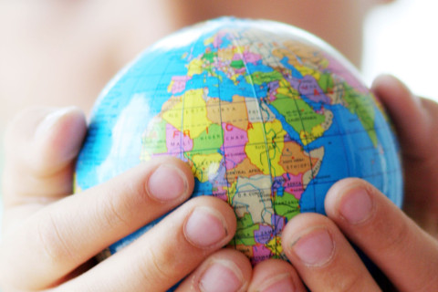 Lapsi pitää käsissään pientä maapalloa