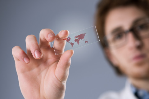 Researcher holding a microscope slide in his hand